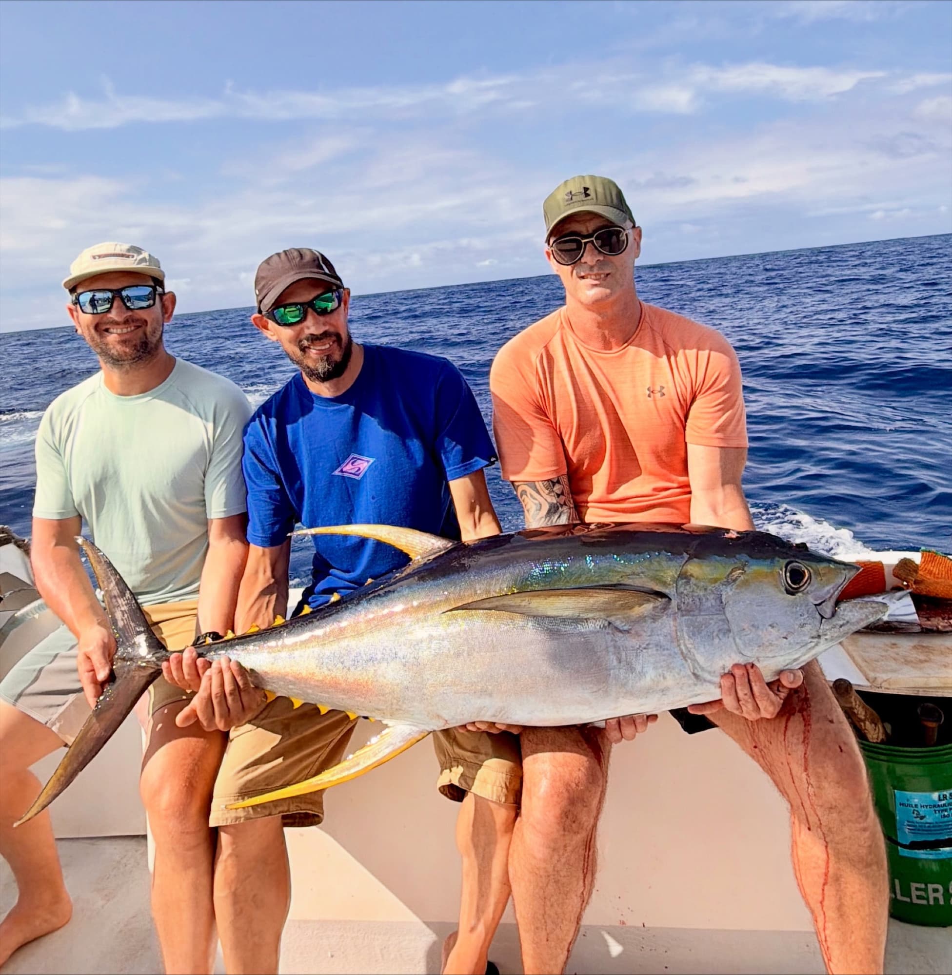 Trois pêcheurs et un thon jaune lors d’une sortie depuis Saint-Gilles
